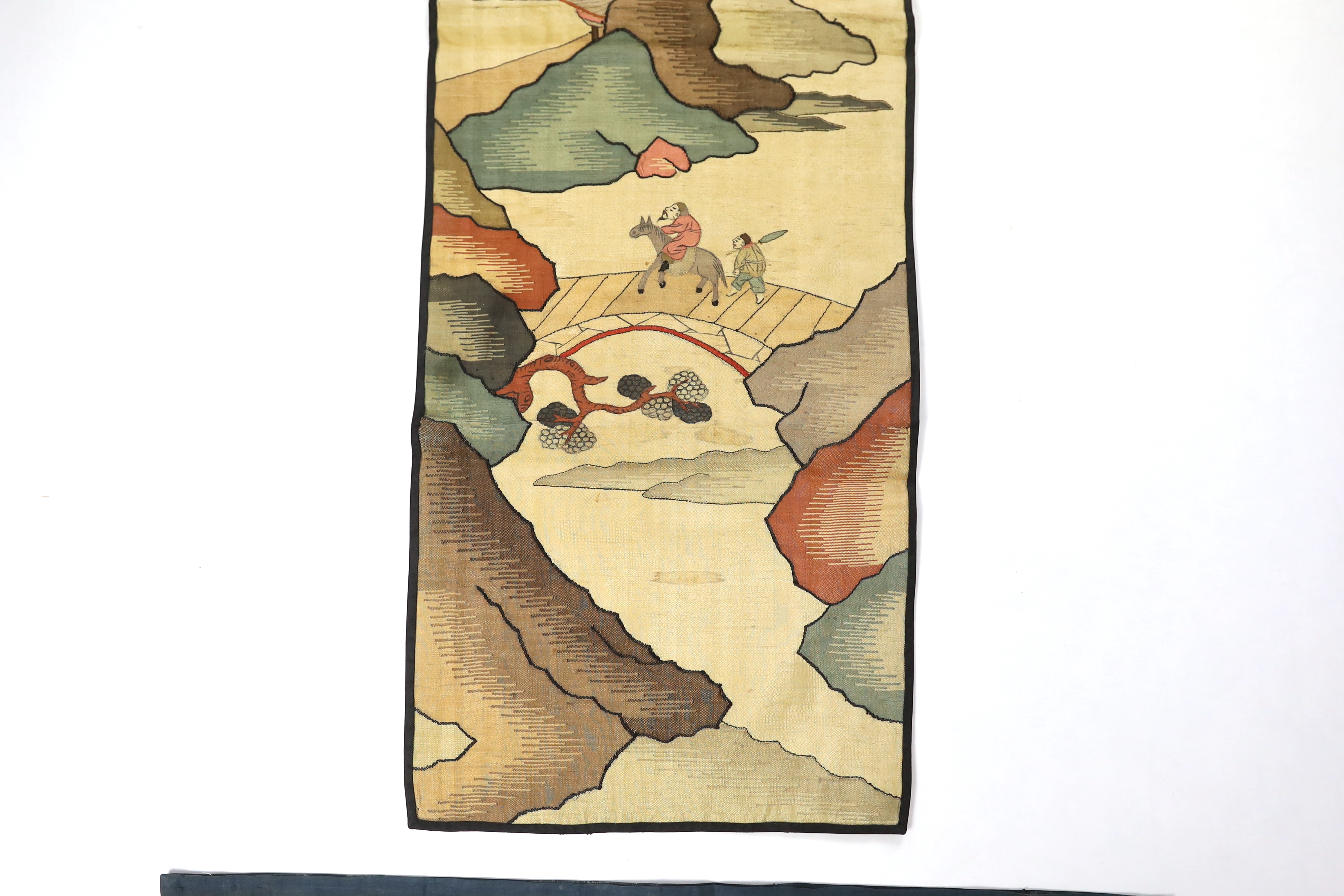 A Chinese late Qing dynasty Kesi polychrome silk hanging, depicting a figure on horseback and another walking within a mountainous landscape, together with a smaller later metallic Kesi panel of stylistic 'lishui waves',